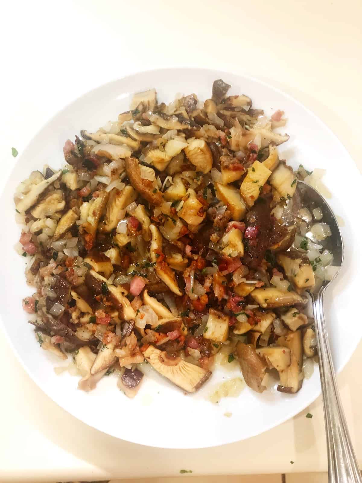 Cooked pancetta and mushrooms on a plate