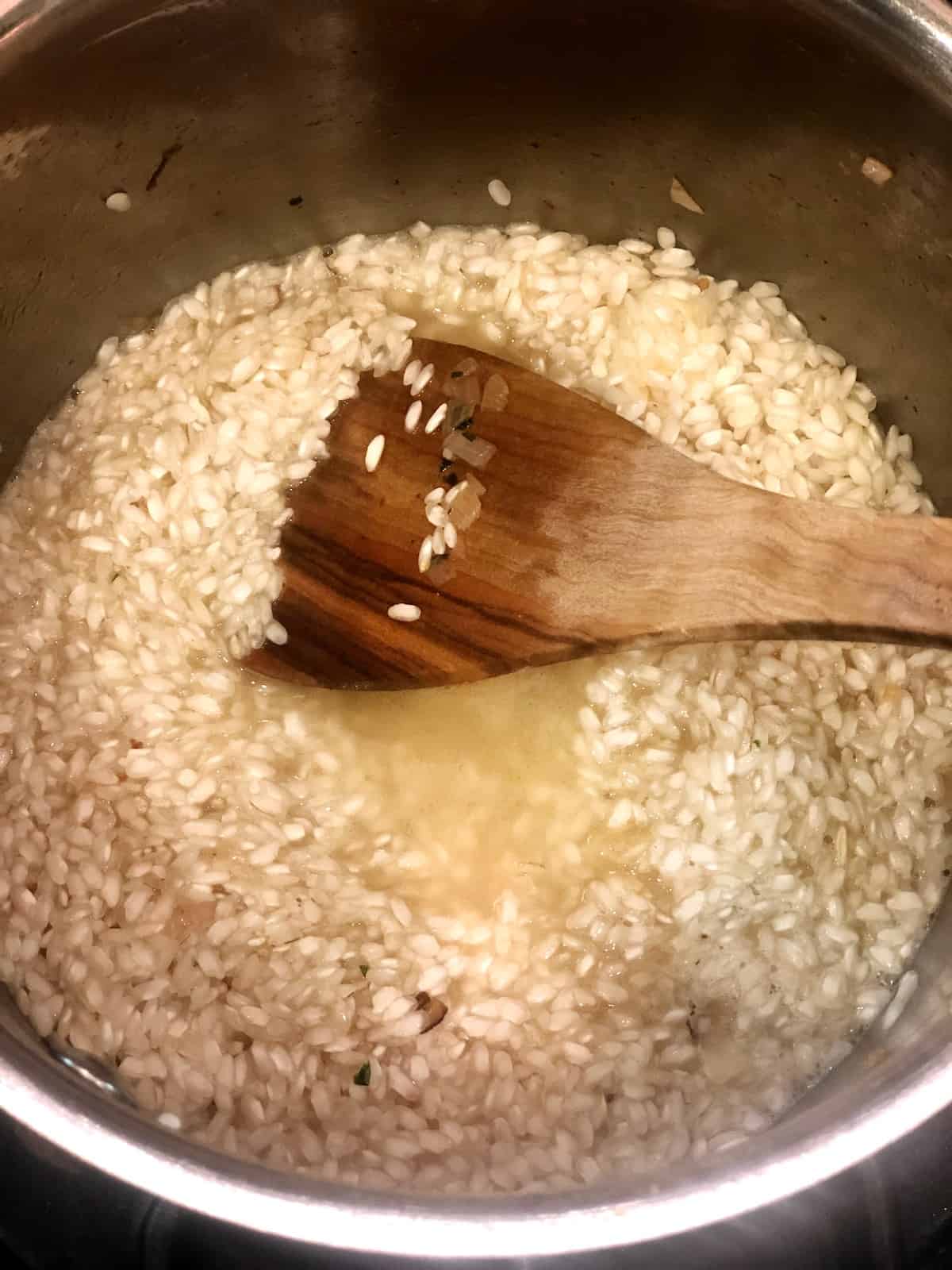 stirring risotto in pot on the stove