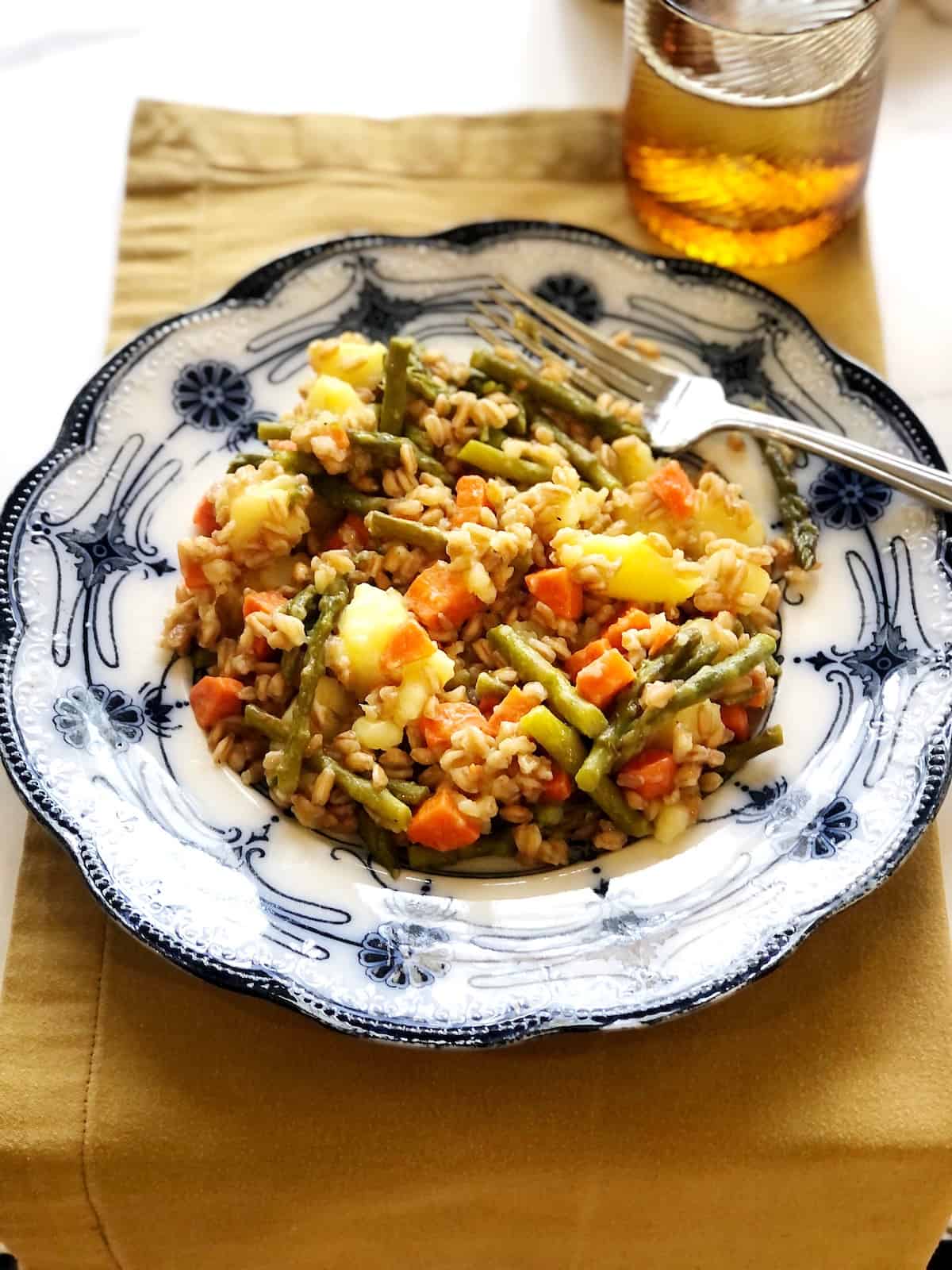 farro and vegetables on plate with yellow napkin