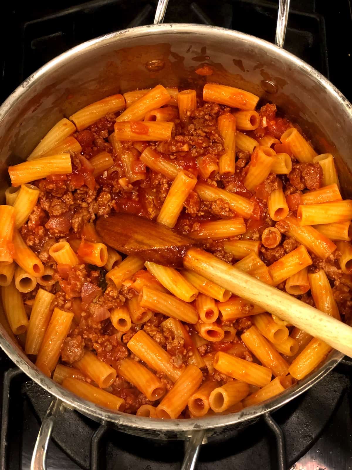 Combining the rigatoni al forno sauce and rigatoni in a large pot.