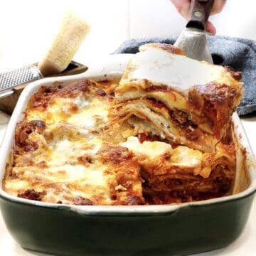 Italian American Lasagna with a piece being cut out of it.