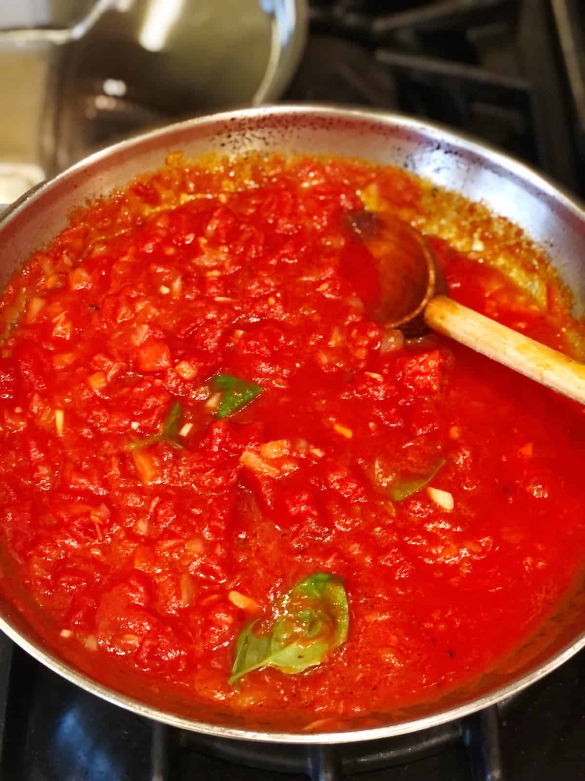 Cooking the tomato sauce for the pork tenderloin in tomato sauce.