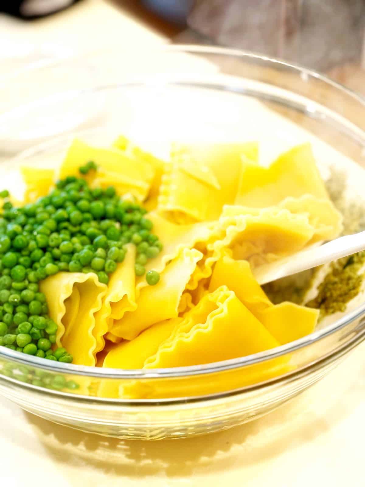 Tossing together the pasta, pesto and peas in a large bowl.