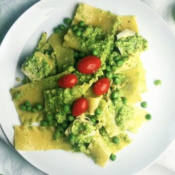 Pasta with pesto and peas on a large plate.