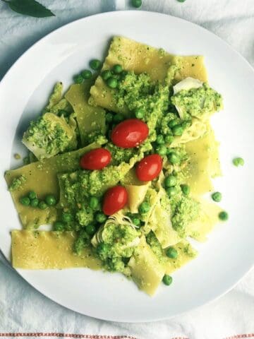 Pasta with pesto and peas on a large plate.