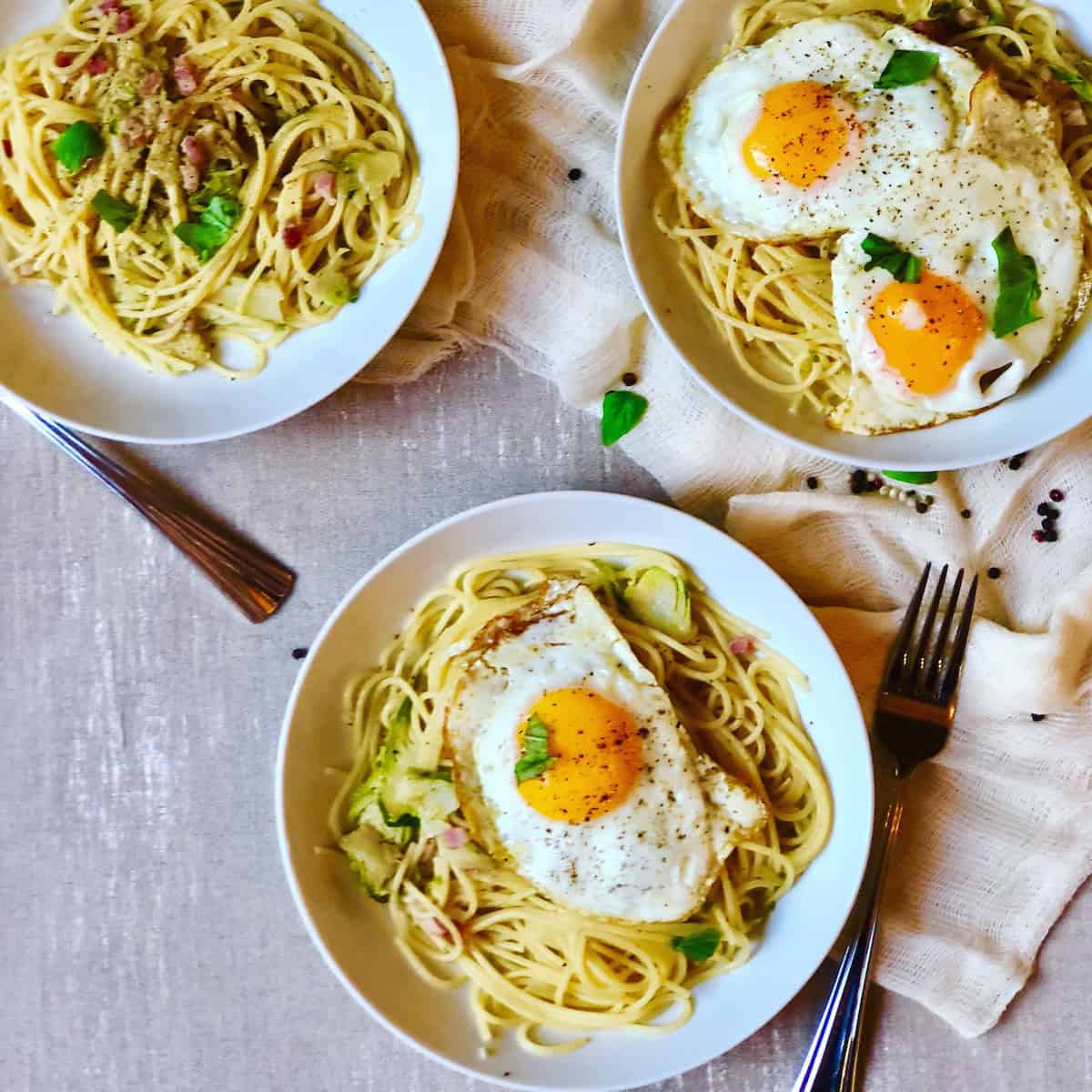 Pasta With Bacon Brussels sprouts and egg in bowls.