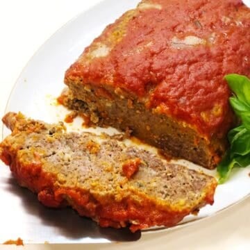 Italian meatloaf baked and sliced on a serving plate.