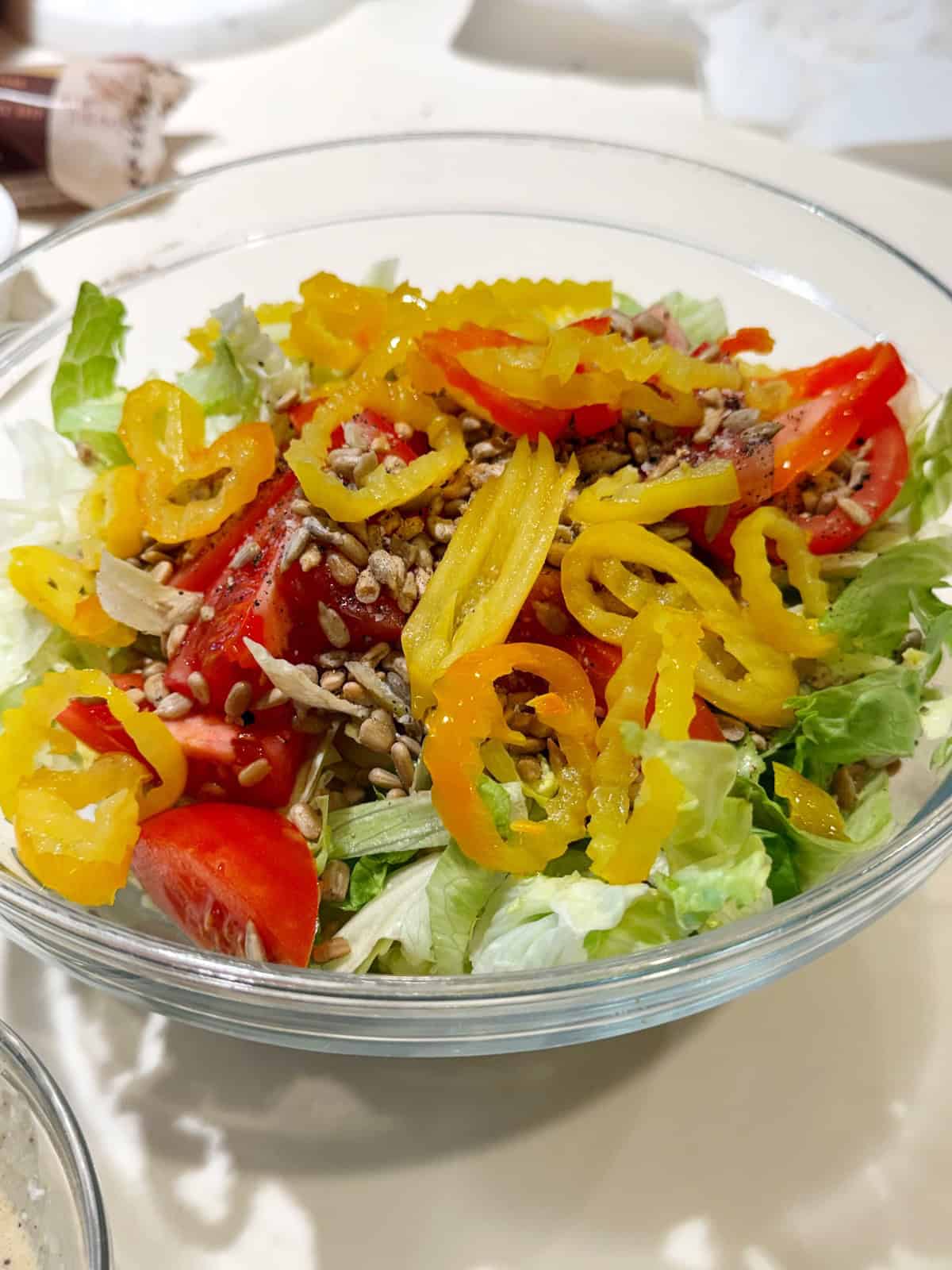 Adding the ingredients for the Italian salad into a bowl.