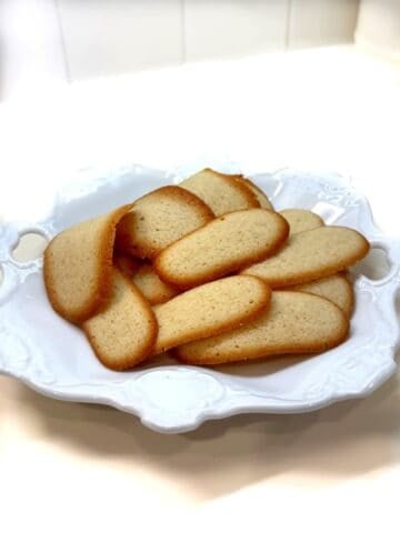 Italian butter cookies (lingue di gatto) on a plate.