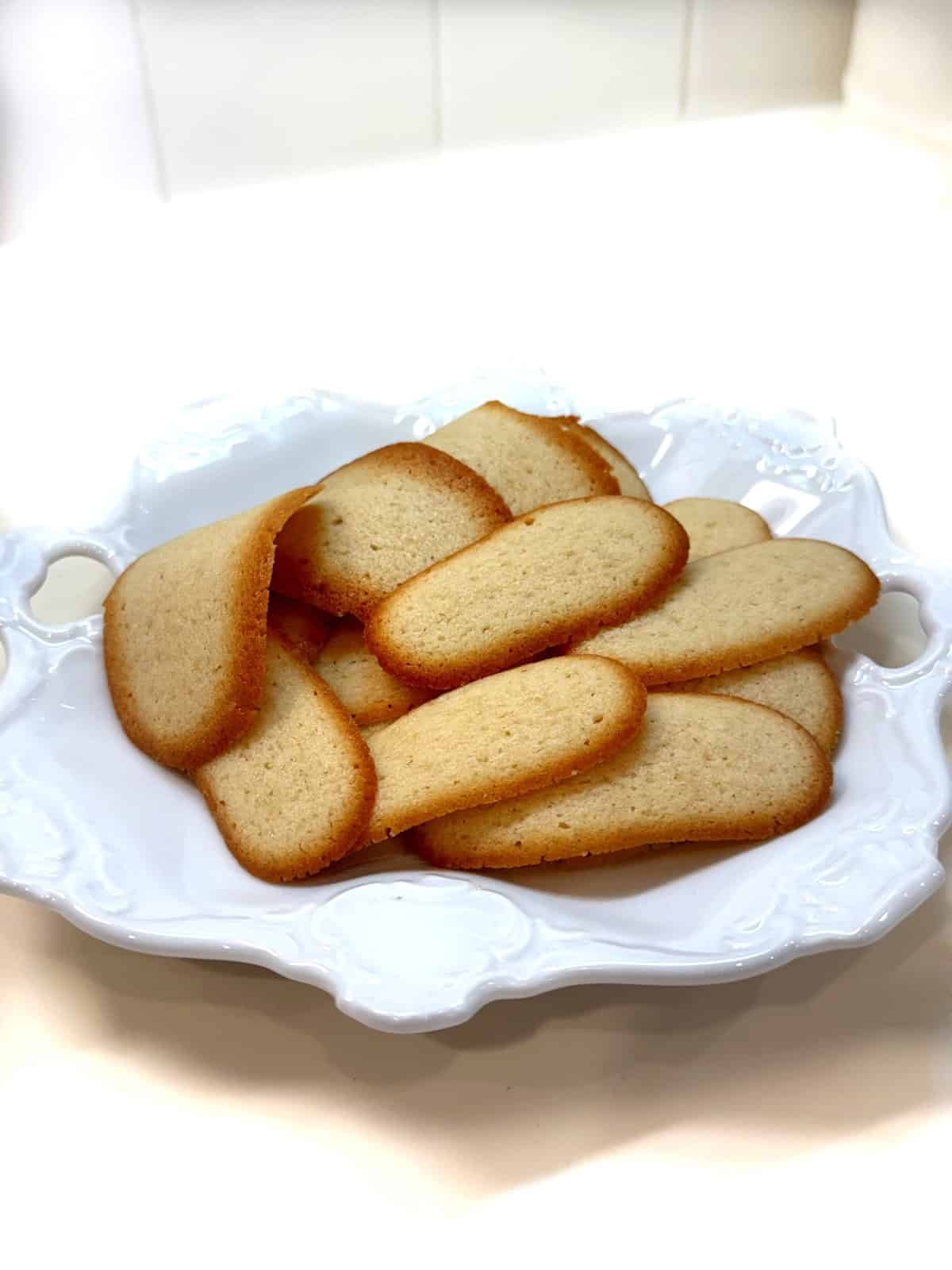 Italian butter cookies (lingue di gatto) on a plate.