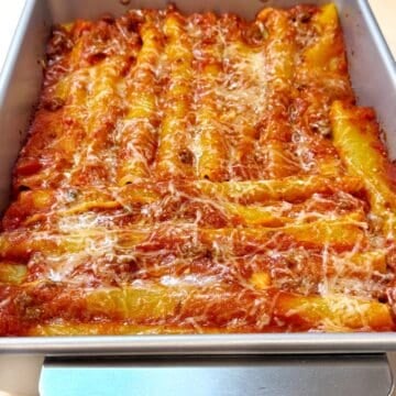 Baked cannelloni with beef in a large baking pan.