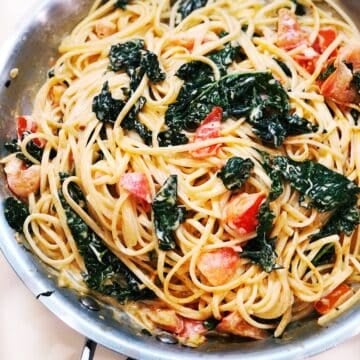 Creamy Spaghetti With Kale And Tomatoes in a saute pan.
