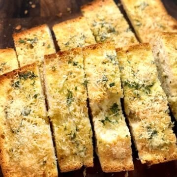 Slices of olive oil garlic ciabatta bread on a cutting board.