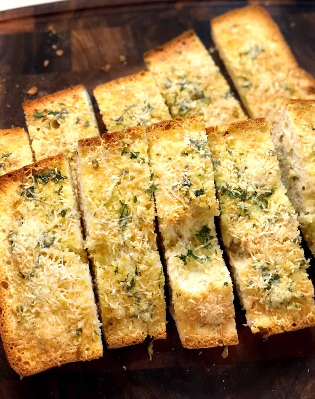 Slices of olive oil garlic ciabatta bread on a cutting board.