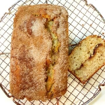 Banana olive oil bread loaf on a cooling rack.