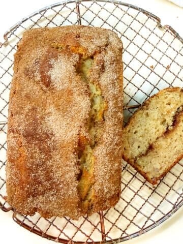Banana olive oil bread loaf on a cooling rack.