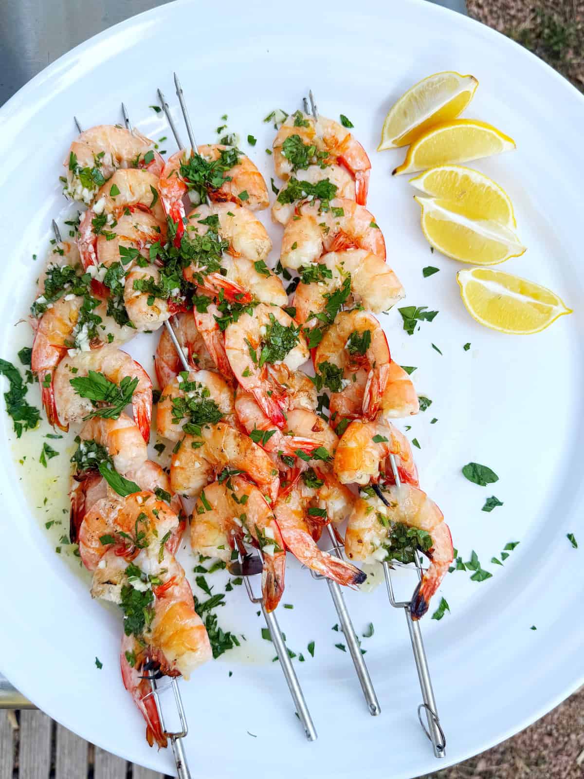 Italian shrimp grilled on skewers on a plate.
