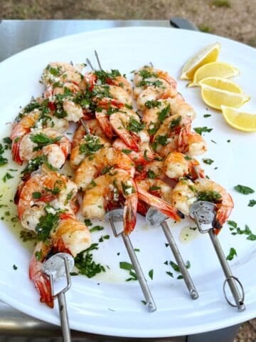 Italian grilled shrimp on a plate with lemons.
